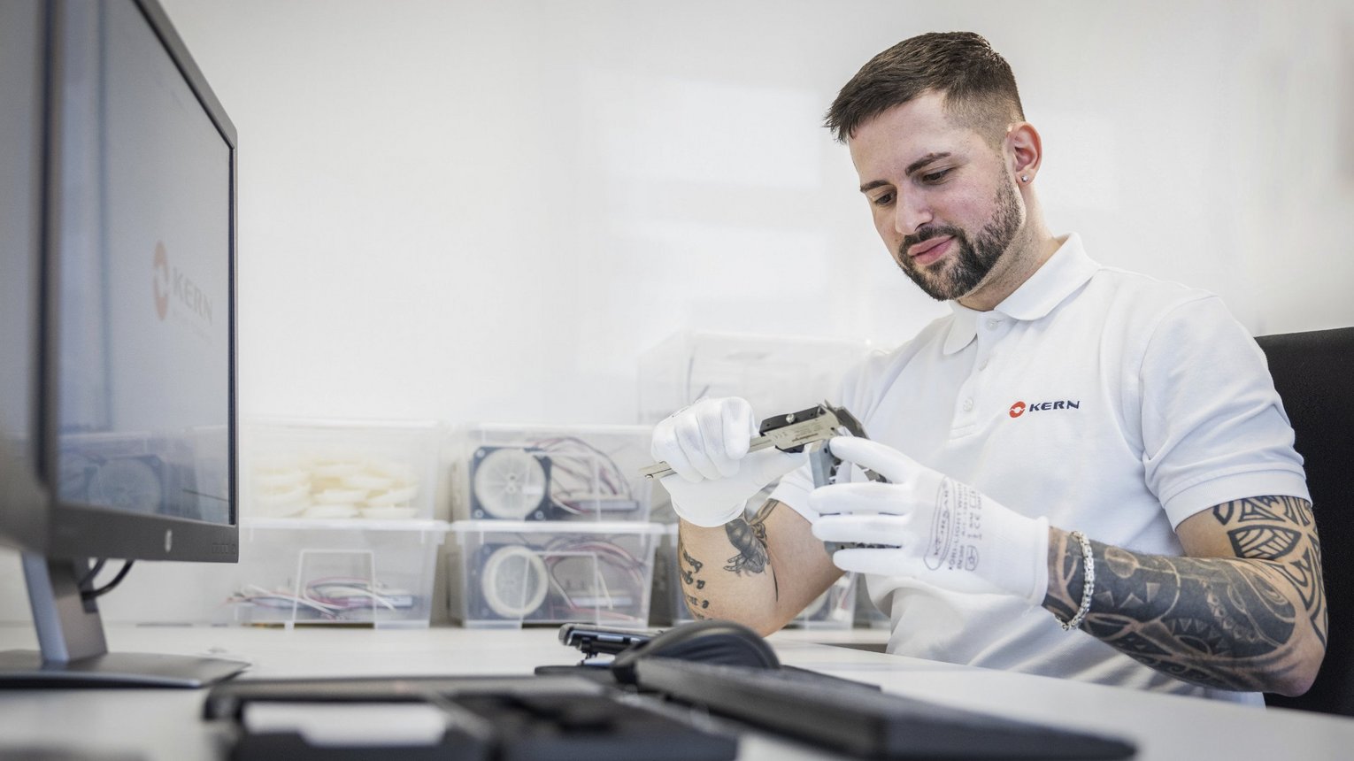 Mann sitzt in sterilem Raum in der Entwicklung bei Kern Antriebstechnik