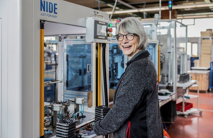 Mitarbeiterin bedient Maschine in Produktion von Kern Antriebstechnik